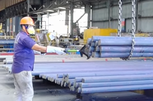 Worker using RiggerSafe to guide a steel bundle
